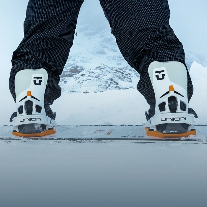 A technician from Sun & Ski Sports helping a customer find properly fitted snowboard boots